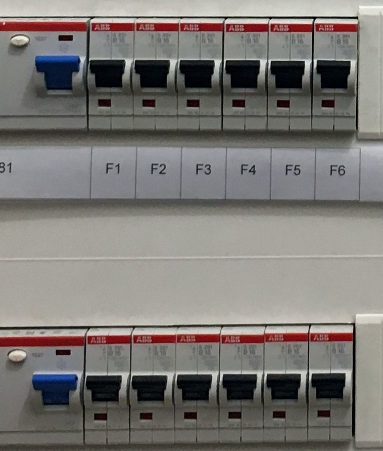 Modern consumer unit fuse board with rows of labelled circuit breakers